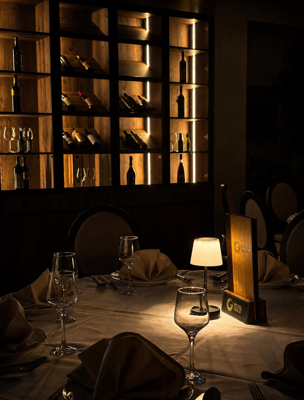 Restoran Hotel Gold — vitrina vina i postavljen stol